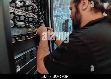 Close up of technician setting up network in server room  Stock Photo
