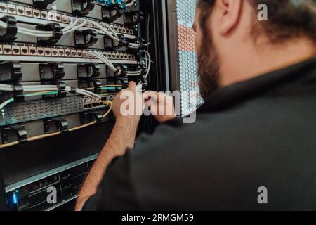 Close up of technician setting up network in server room  Stock Photo