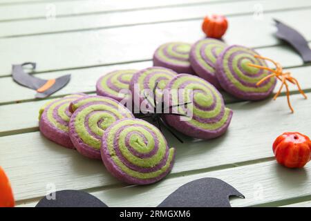 Tasty cookies with Halloween decorations on green wooden background Stock Photo