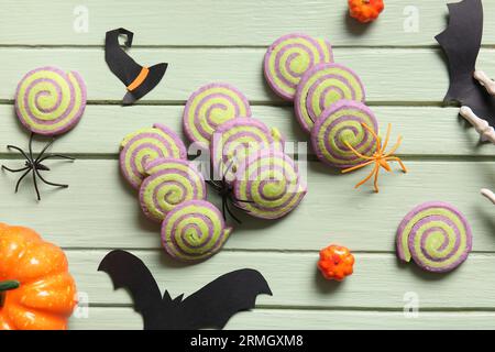 Tasty cookies with Halloween decorations on green wooden background Stock Photo