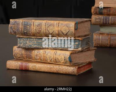 Pile of old vintage books lying on a black table. Stock Photo