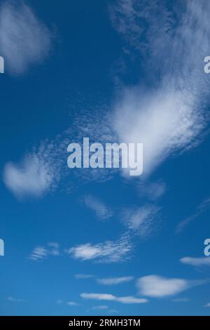 Cute wispy clouds in a blue sky. Stock Photo