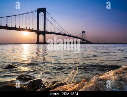 View of the Whitestone Bridge in Queens, New York City at sunset with the water of the Long Island Sound in view. Stock Photo