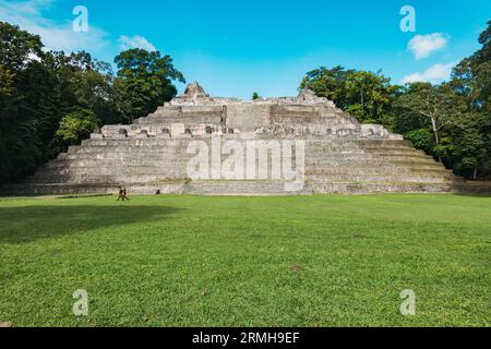 Belizean soldiers walk past Caana ('Sky Place'), the largest temple at Caracol, a Mayan city ruins dating back to 1200 BCE located in Belize Stock Photo