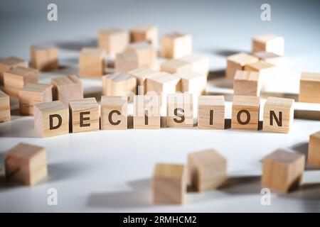 Word DECISION written on wooden cubes among a lot of others, concept to make the right choice in business and job, gray background, copy space, select Stock Photo