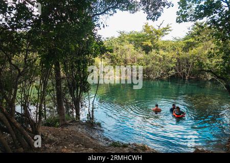 people swim in the crystal clear waters of Crater Azul (Blue Crater) in northern Guatemala Stock Photo