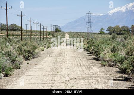 old abandoned road in the Owens Valley with power lines and heat ripples Stock Photo