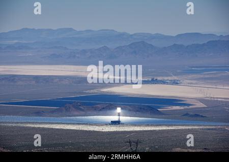 Mojave Desert solar power plants including one of the Ivanpah thermal solar towers and mirror array and photovoltaic panels and Primm Nevada Stock Photo