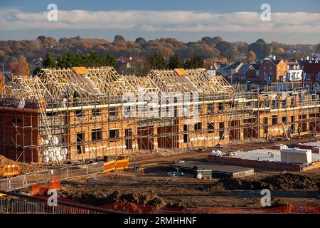 New housing estate at various stages of construction: from excavations to ground-floor foundations, from first-floor walls to roofs nearly completed. Stock Photo