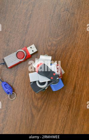 Closeup of several USB sticks on the wooden table. Several different USB sticks. Flash drives representing mobile storage and advanced technology. Stock Photo