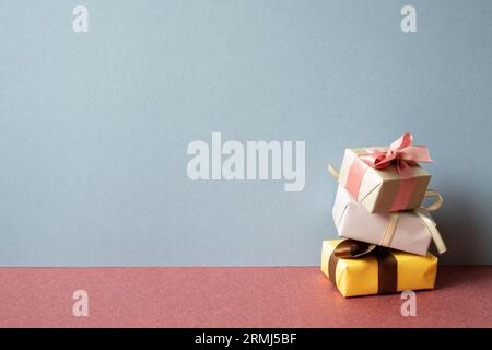 Stack of colorful gift box on red table. gray wall background Stock Photo