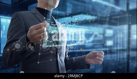 Asian businessman in the office interacting to augmented reality or virtual touch screen reviewing graph for business data analysis Stock Photo