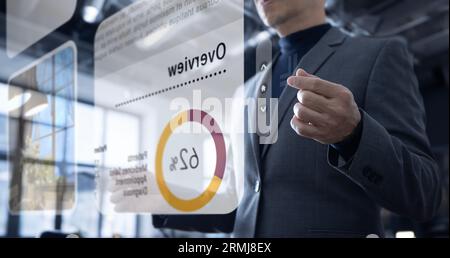 Asian businessman in the office interacting to augmented reality or virtual touch screen reviewing graph for business data analysis Stock Photo