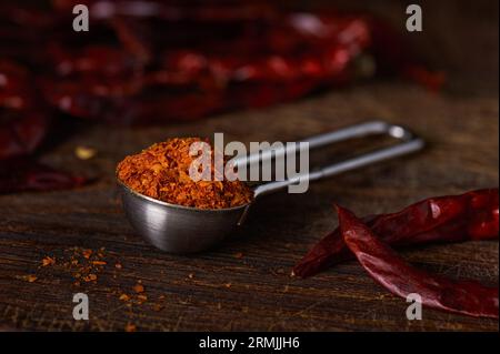 Measuring spoon with ground pepper on a wooden surface Stock Photo