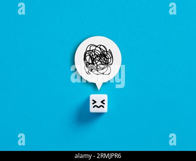 Stress, anger, confusion, depression or distress concepts. Cube with unhappy face with a tangle of thoughts in its head. Stock Photo