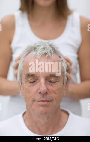 Close up of gray haired man receiving head massage Stock Photo
