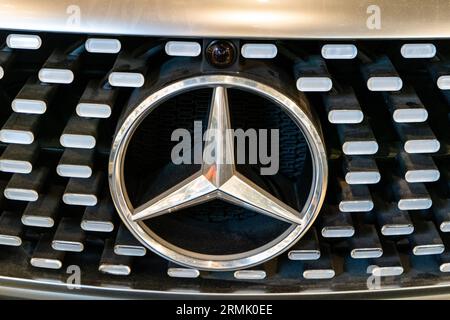 Silver Mercedes car. Bumper and headlights. Logo emblem on the hood. Mercedes-Benz stylish luxury business class vehicle. Warsaw, Poland - 28.07.2023. Stock Photo