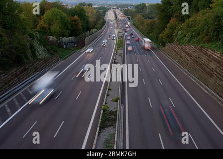 Night lights from car headlights on roundabout in night city. Traces of headlights on the road at night, long exposure. Drone aerial shot. Panoramic a Stock Photo