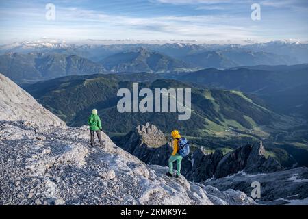 Two hikers looking down into the valley from the Hochkoenig, Salzburger Land, Austria Stock Photo