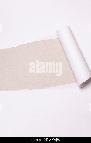 Torn paper with opening showing cardboard paper background. Stock Photo