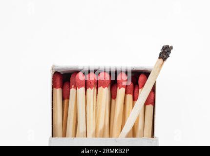 Box of matches and one burnt close up top view on white Stock Photo