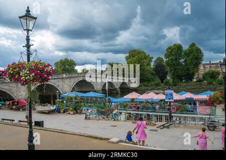 View from Richmond Riverside towards Richmond Bridge. People dining al fresco aboard Peggy Jean restaurant boat. Richmond, London, England, UK Stock Photo