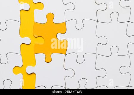 High angle view yellow puzzle piece arranged with white pieces Stock Photo