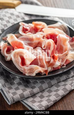 Italian panchetta. Sliced smoked bacon on the plate. Stock Photo