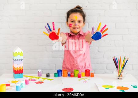 Smiling portrait girl showing her painted colorful hand camera Stock Photo