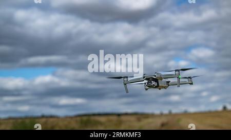 A DJI Air 2S Drone low to the ground as it hovers whist filming Stock Photo