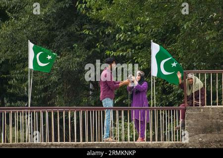 August 25, 2023, Keran, Jammu and Kashmir, India: Local tourists in Pakistan administered Kashmir seen taking photos on the banks of Neelam river or Kishan Ganga which acts as a line of control between nuclear-armed neighbours India and Pakistan, at Keran village in Kupwara district, some 150km north Srinagar. The highly restricted border area was a battle field and used to witness intense shelling and gunfire, now a most attractive tourist hotspot after the 2021 ceasefire pact between the armies of India and Pakistan. (Credit Image: © Faisal Bashir/Pacific Press via ZUMA Press Wire) EDITORIAL Stock Photo