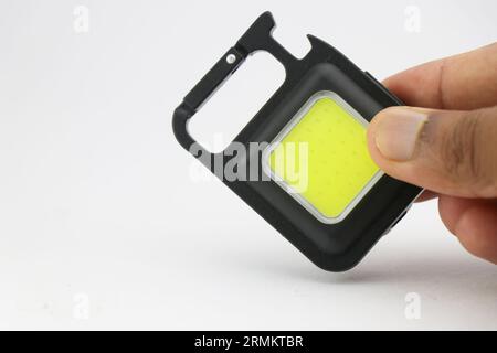 Small keychain pocket light with multiple features perfect during outdoor camping activities held in hand with space for copy text Stock Photo