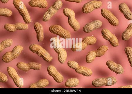A bunch of fresh peanuts in a crunchy shell on a pink background. Stock Photo