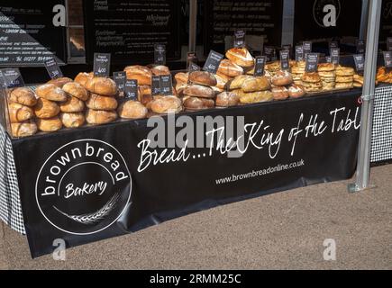Fresh loaves of artisan bread on sale at street market stall, BrownBread bakery, Woodbridge, Sufffolk, England, UK Stock Photo