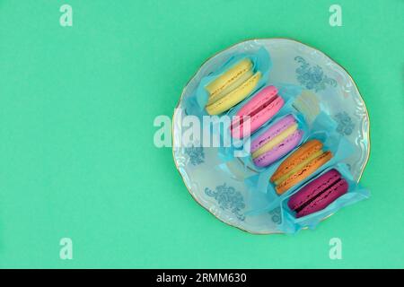 Marshmallows in plate on green background. Traditional colored sweet desserts for the holiday. Stock Photo