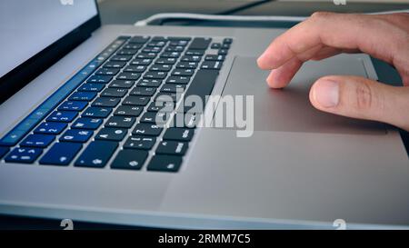 Hand on laptop touchpad Stock Photo