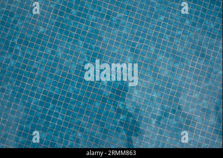 Pattern of blue pool tiles under water close up view background Stock Photo