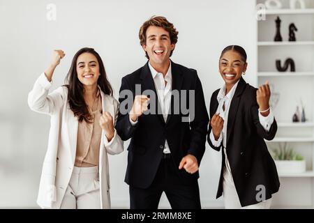Excited multiethnic business colleagues celebrating teamwork success, achievement, clenching fists and rejoicing victory Stock Photo