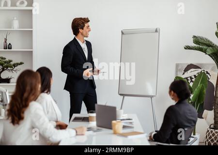 Businessman leader giving presentation on mockup empty whiteboard to business team in conference room Stock Photo