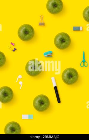 Back to school flat lay with green apples on yellow background. Stock Photo