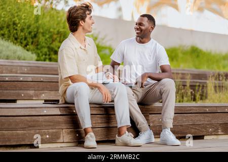 Two young men multiracial students hanging out at university campus Stock Photo