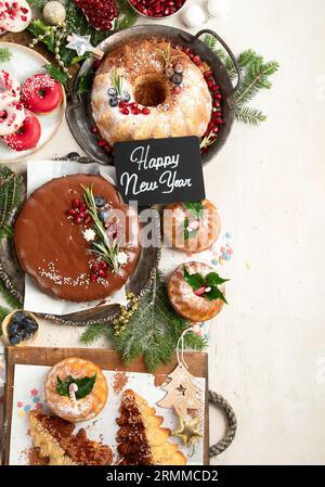 Assorted Christmas holiday desserts and sweets on a white background. Top view. Bundt cake, chocolate pie, cookies and donuts. Stock Photo