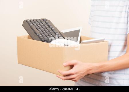 Donate technology to charity. Volunteer hands holding cardboard box with text old used laptop computers, phone, tablet, headphones. Donation box for e Stock Photo