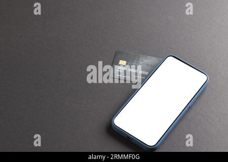Smartphone with blank screen and credit card on black background Stock Photo