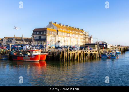 Boats moored in West Bay Harbour in evening sunset in summer sunshine; West Bay, Dorset England UK. Dorset landscape. Stock Photo
