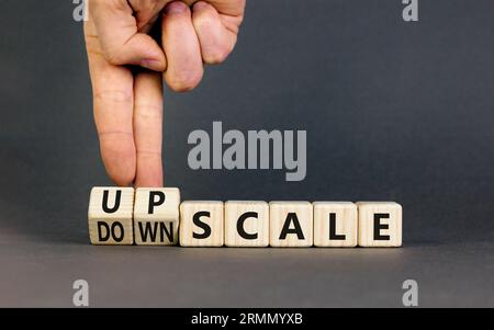 Upscale or downscale symbol. Concept words Upscale or Downscale on wooden cubes. Beautiful grey table grey background. Businessman hand. Business upsc Stock Photo