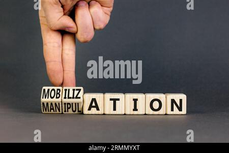 Mobilization or manipulation symbol. Concept words Mobilization Manipulation on wooden cubes. Beautiful grey background. Psychologist hand. Psychology Stock Photo