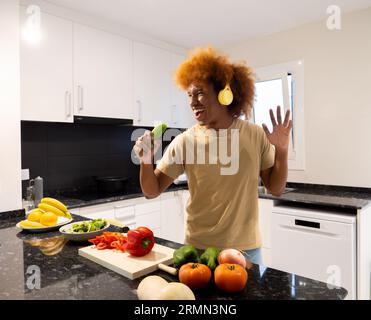 Young African American man having a good time in a kitchen with vegetables. cooking happy Stock Photo