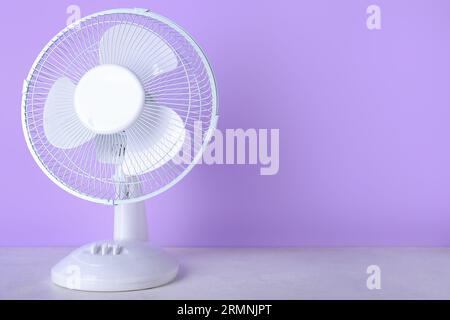 Electric fan on lilac background Stock Photo