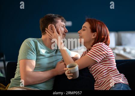 Happy middle aged family couple enjoying each other, woman touching man's cheek looking in his eyes. Stock Photo